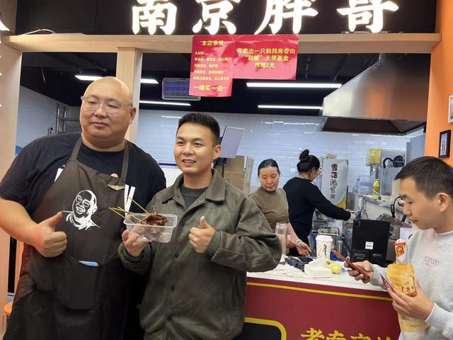 时不时就会有主动要求和邱绍春合影的顾客。 杨书源 摄