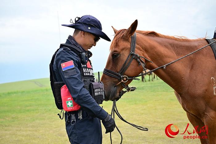 “海东青”骑警队队员达林台和他的队友“清风”。人民网记者 寇雅楠摄