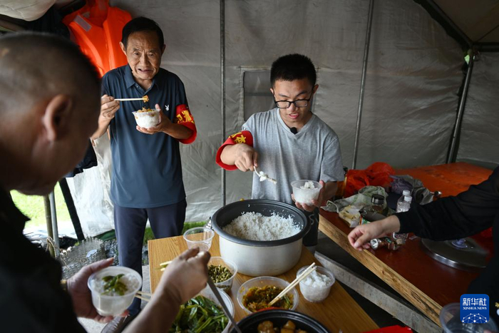 　　7月2日，谭康（右一）在防汛工棚内准备吃午饭。新华社记者 周牧 摄