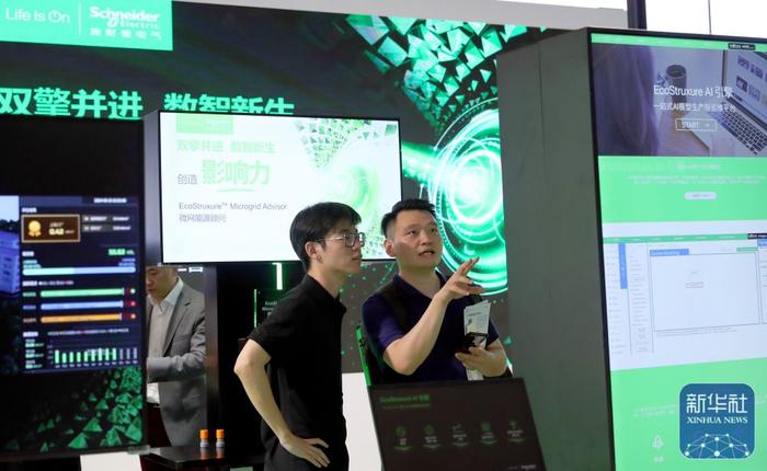 7月4日，参观者在一组AI模型平台演示屏幕前交流讨论。新华社记者 方喆 摄