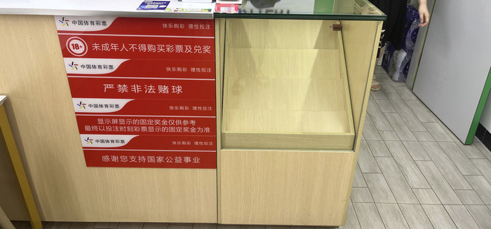 许超经营的体彩店内，原本摆放即开型彩票“顶呱刮”的柜橱，如今因缺货而显得空荡荡。（图源：时代财经 李益文/摄）