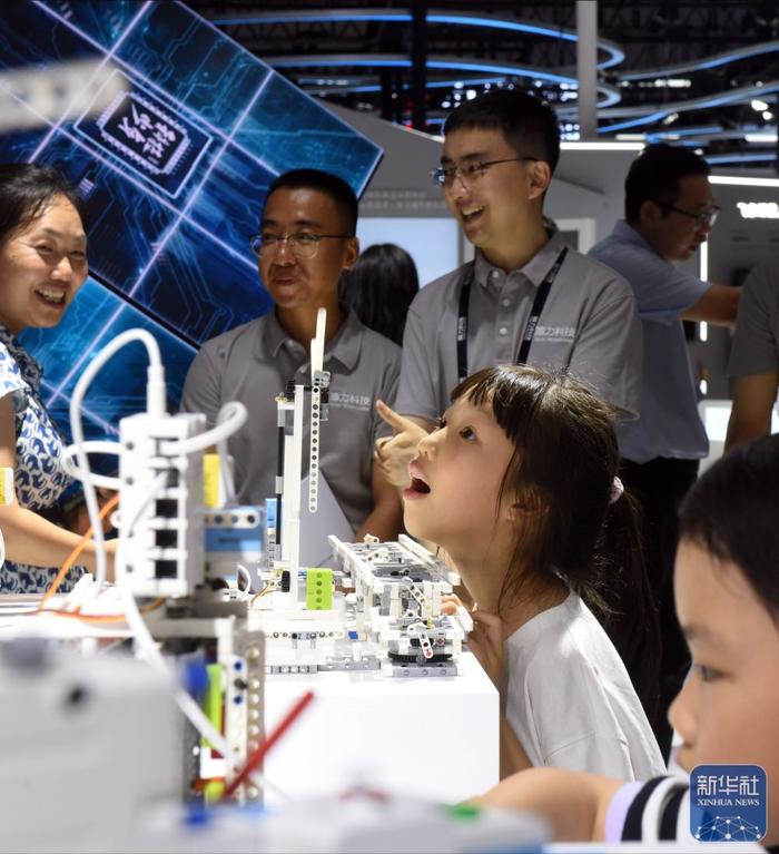 7月4日，在猿力科技展台，两名女孩在体验“编程智能硬件”。新华社记者 黄晓勇 摄