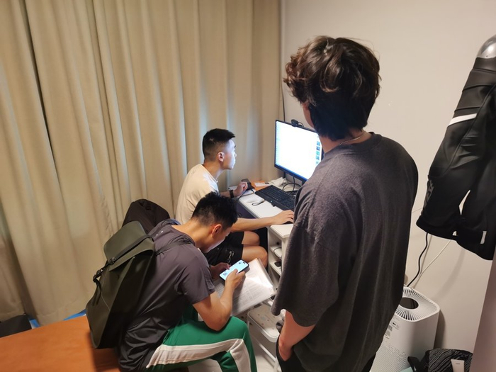 执法人员查看当事人电脑及手机取证。 陈玺撼摄