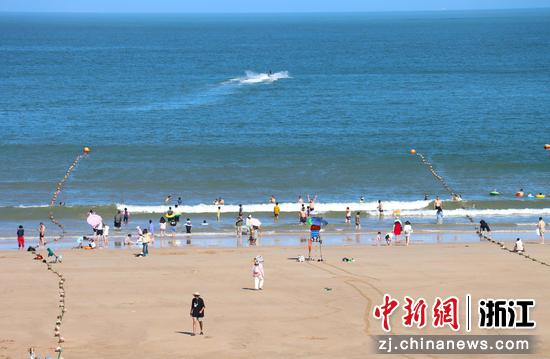 游客们在海边嬉戏。 周健 摄