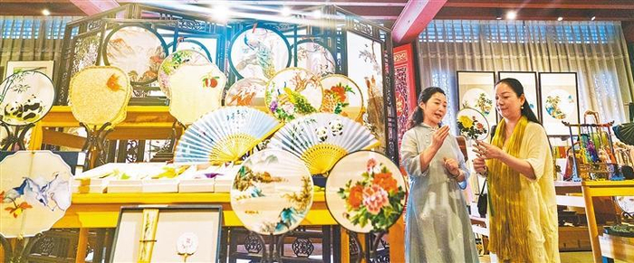 　　7月3日，位于成都太古里附近的一家蜀绣蜀锦精品店，工作人员在介绍蜀绣制品。