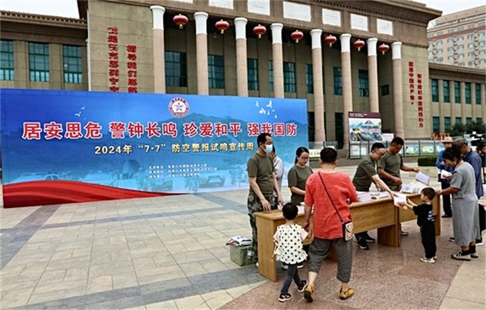 图为张家口市国防动员办公室工作人员向市民发放国防动员宣传资料。