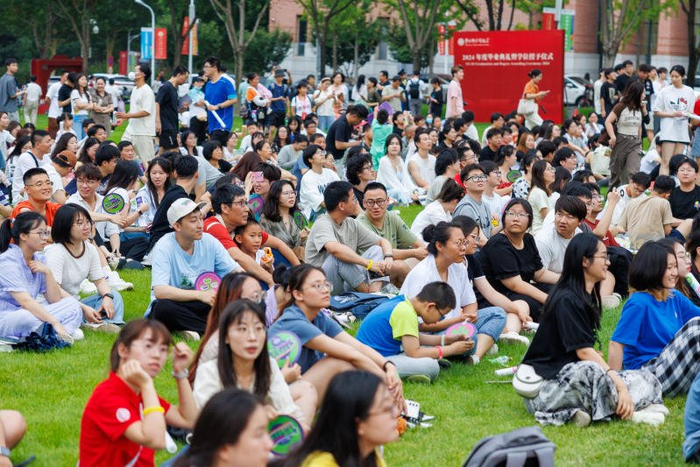 参加音乐节的师生和家长席地而坐，欣赏音乐。新京报记者 王子诚 摄