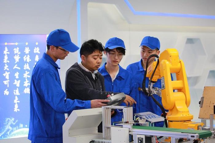   铜陵职业技术学院工业机器人技术专业学生在教师的指导下学习工业机器人操作技能。（潘伟 摄）