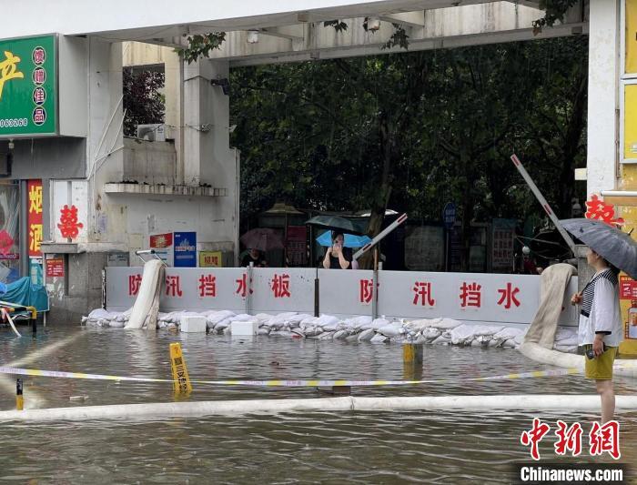 图为郑州一小区出入口因积水被防汛挡水板及沙袋封堵。闫吉庆 摄