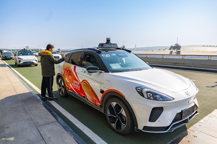 ▲1月24日，旅客在机场航站楼前体验“萝卜快跑”自动驾驶汽车 据ICphoto