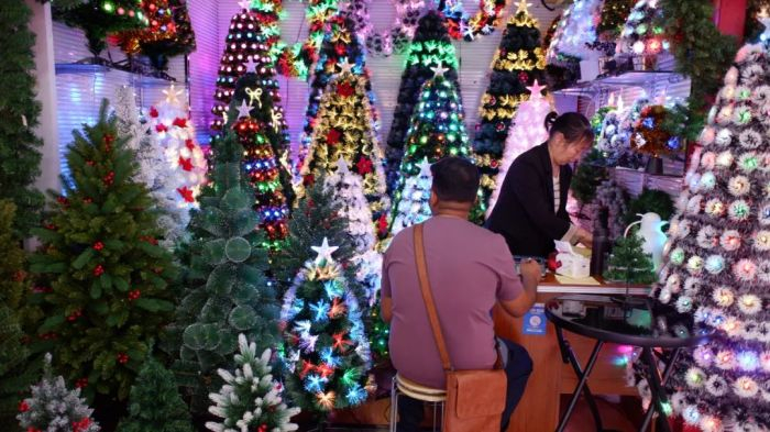 义乌国际商贸城一区，一位外国客人在店里看圣诞树。图 / 每日人物摄