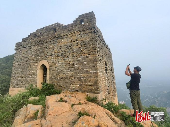 7月5日，张鹏在拍摄长城敌楼，准备上传巡查照片。河北日报记者孙也达摄