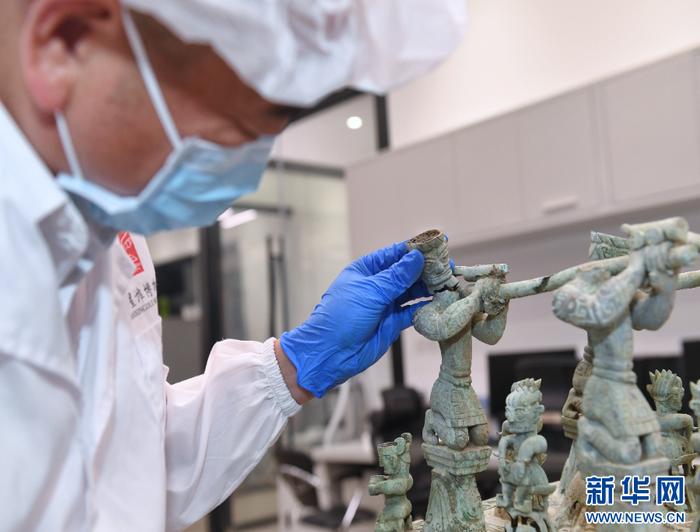 郭汉中将断开的神坛底座抬杠力士像头部与身体进行比对。新华社记者 刘坤 摄