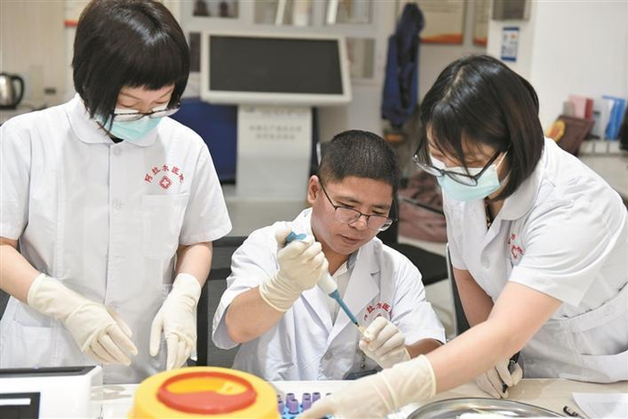     浙江大学医学院附属邵逸夫医院新疆兵团阿拉尔医院检验科特聘主任赵锋（中）在进行标本检测（资料图片）。