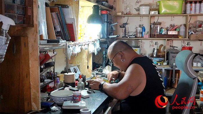 守艺工作室苏力迪正在研究顾客定制的银饰品样式。高旭摄