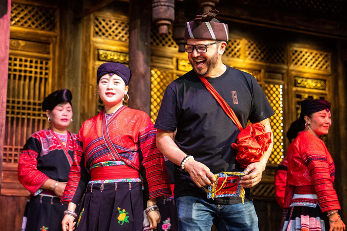 在广西龙胜黄洛瑶寨，外国游客与村民演员在红瑶民俗文化表演中互动（6月26日摄）。新华社记者 陈思汗 摄