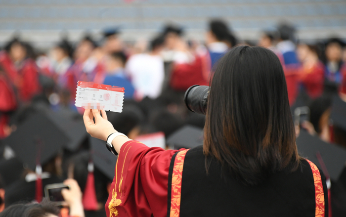 ▲资料图：某高校毕业典礼现场，学生正在拍照留念。图/新华社