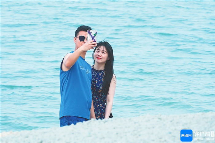 资料图：一对情侣在琼海潭门海边自拍。