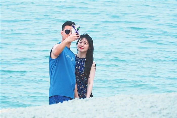 一对情侣在琼海潭门海边自拍。本文图片除署名外均为资料图
