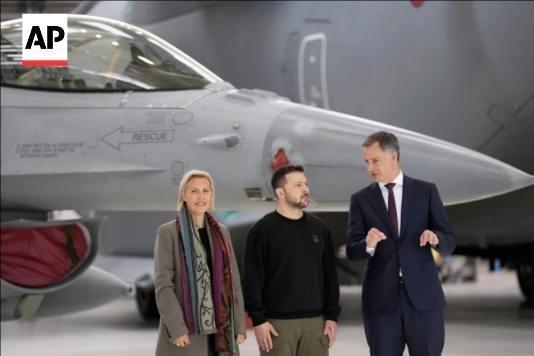今年5月，比利时首相(右)和防长(左)与乌总统泽连斯基在F-16战机前合影。图/美联社网站截图