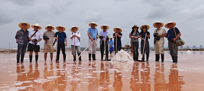参加采风活动的媒体记者在定边盐场体验打盐作业