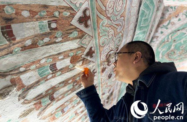 敦煌研究院相关工作人员正在进行壁画修复。人民网记者 徐冬儿摄