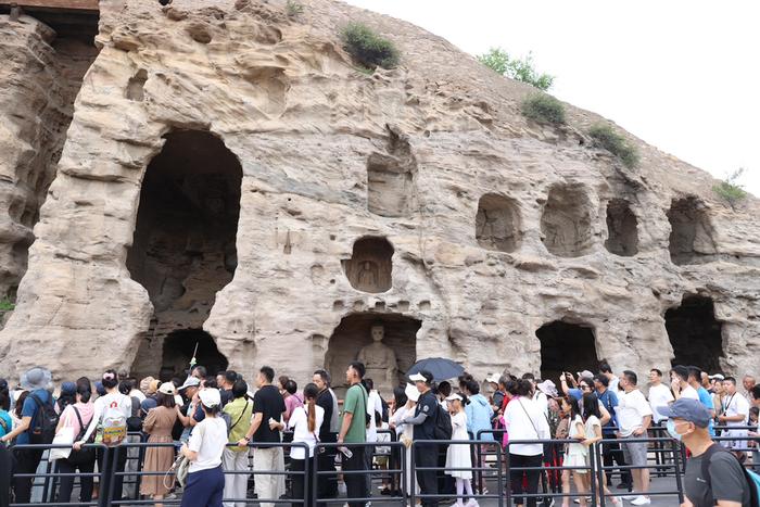 7月15日，游客在山西省大同市云冈石窟景区内参观。 朱兴鑫 摄