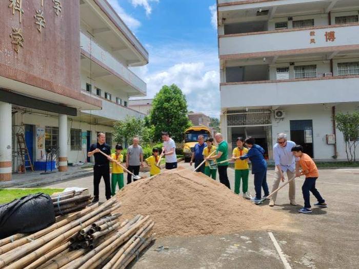 石明小学校园修缮项目的资助方代表与学校师生们共同启动开工仪式。