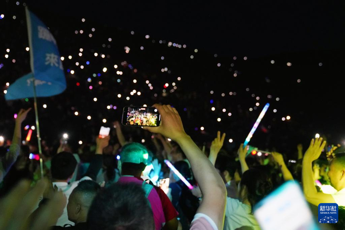   7月15日晚，游客在敦煌鸣沙山月牙泉景区参加万人星空演唱会。新华社记者 马宁 摄