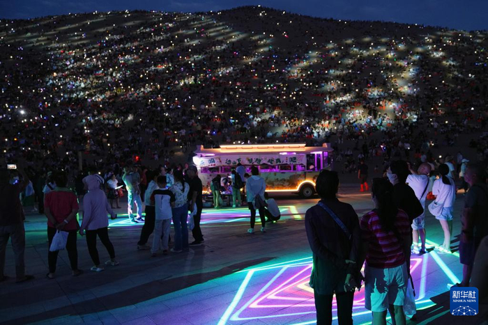   7月15日晚，游客在敦煌鸣沙山月牙泉景区参加万人星空演唱会。新华社记者 马宁 摄