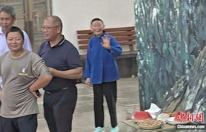   段桂秀向记者们挥手道别。何显津 摄