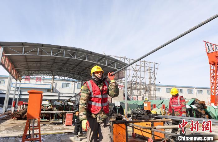 2月22日，北京地铁平谷线永顺站施工现场，工人搬运加工好的钢筋。记者贾天勇摄