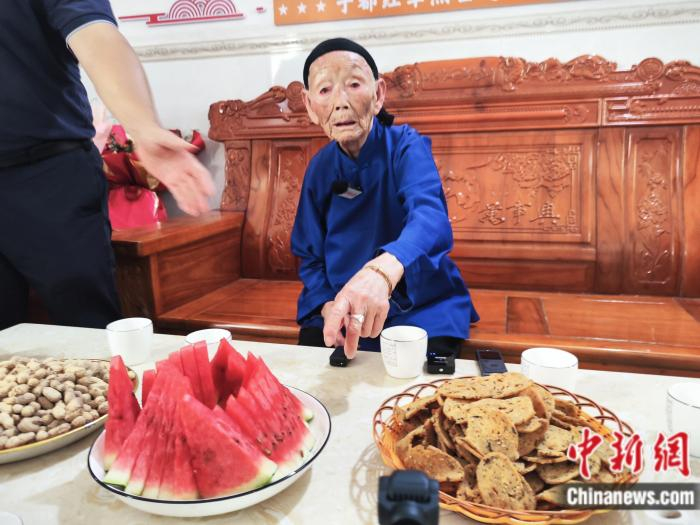   段桂秀招呼记者们吃水果。刘越 摄