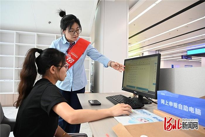 6月24日，在张家口市民中心网上申报专区，市民在帮办人员指导下办理业务。 本报记者 郭晓通摄
