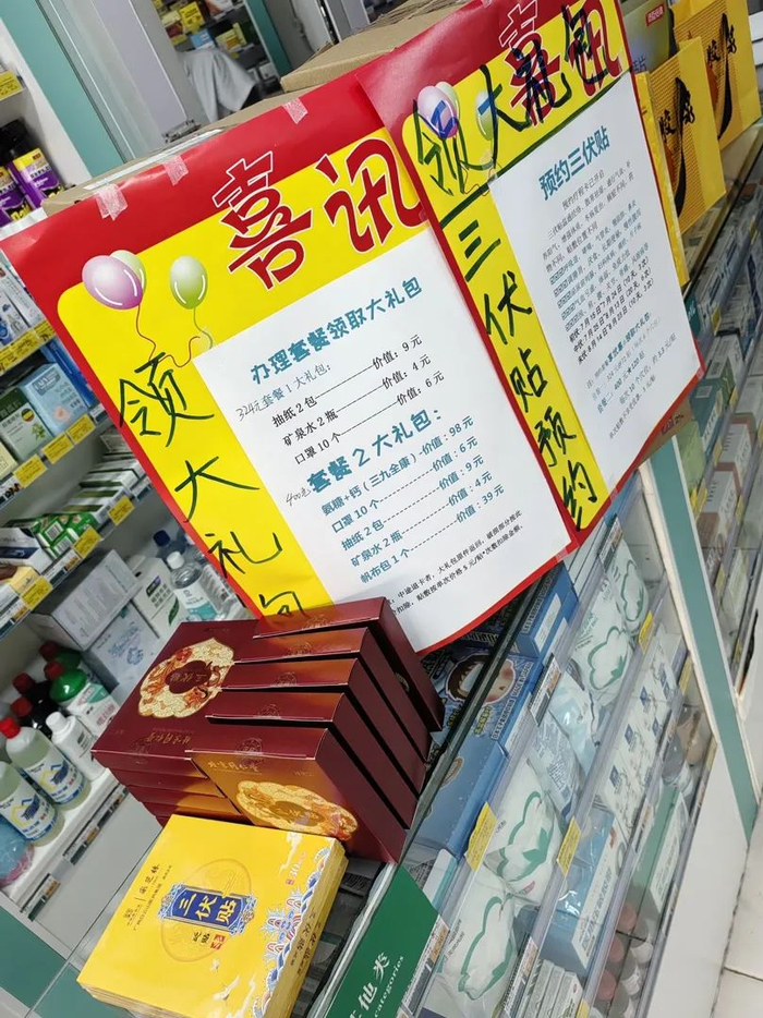 一家药店柜台处摆放着盒装三伏贴和预约广告