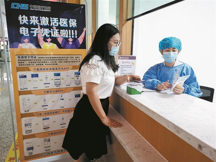     在十三师红星医院结算窗口，工作人员通过医保电子凭证为参保人员办理门诊慢病结算手续（资料图片）。张晓华  摄