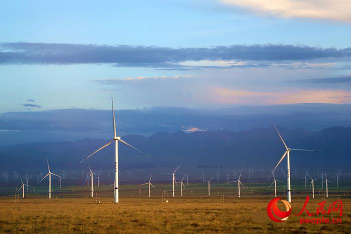 青海省海南藏族自治州共和县境内，大型风力发电机随风旋转，汩汩绿电在这里积聚，一路向东，点亮中原之灯。人民网记者 杨启红摄