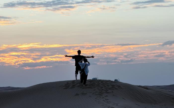 7月16日，青年人在“青春漠漠搭”沙漠营地拍照（无人机照片）。新华社