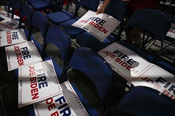 美国共和党全国代表大会上，一名工作人员在椅子上摆放“炒了拜登”的标牌。 视觉中国