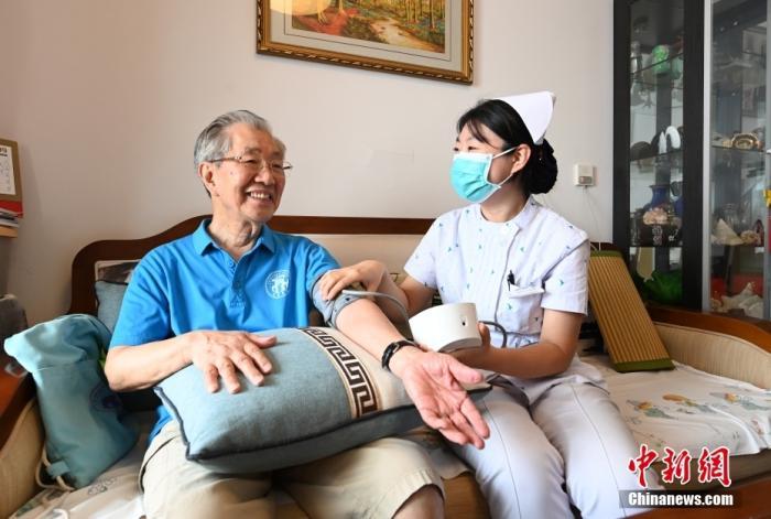   资料图：医务人员正为健康养护中心入住老人测量血压。中新社发 刘向 摄