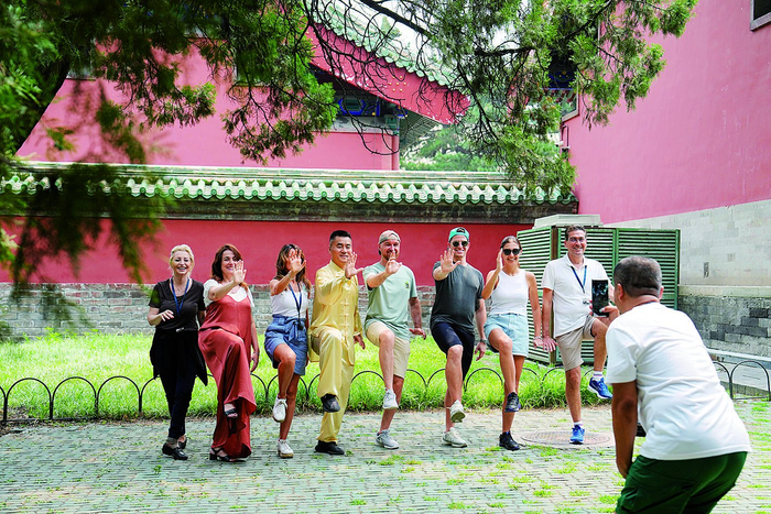     来自意大利的游客在北京天坛公园体验太极拳后合影留念