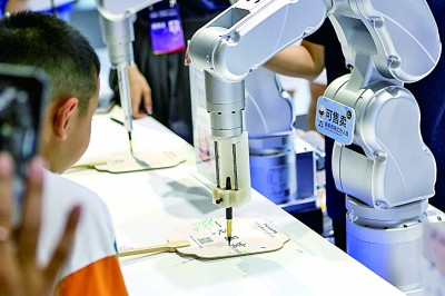 　　人工智能机械手臂进行文字创作表演。新华社发