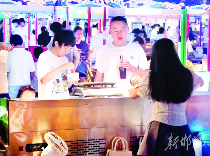 图为市民正在品尝小吃。