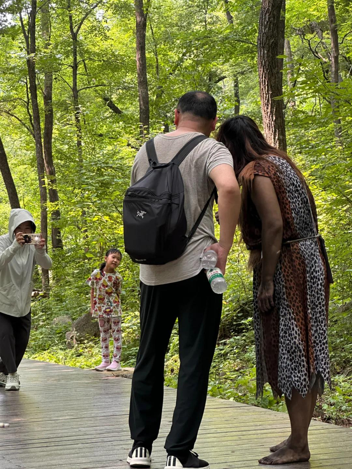 游客们和野人合照。（图/新周刊 摄）