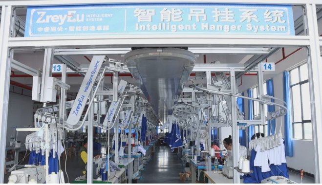 图为布嘉迪服饰有限公司的生产车间的智能吊挂系统。