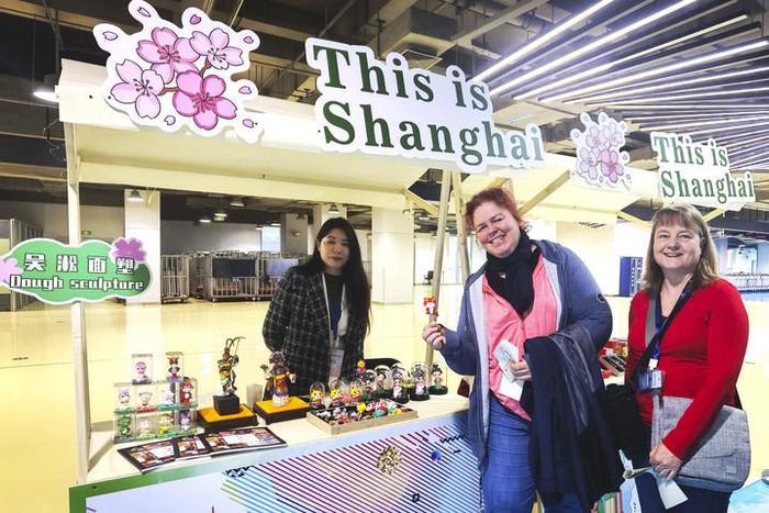 4月6日，外国游客在上海吴淞口国际邮轮港游客通道的非遗展示摊位合影。（陈爱平 摄）