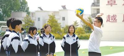 甘旭向学生示范排球的发球动作。肖杰  摄