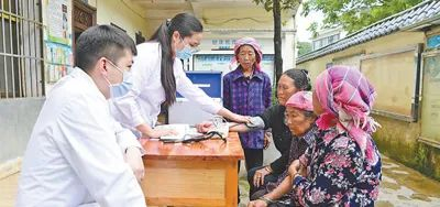 支医人员、医生傲瑞远（左一）和护士何喜（左二）为村民进行健康检查。毛虹  摄