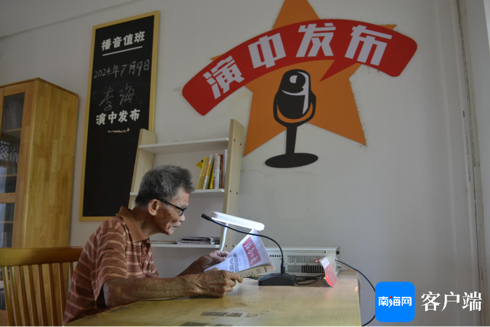 吴育民在读报。记者 贺立樊 摄