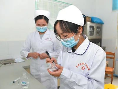 支医人员、护士李文瑞（右）和护士何喜在为患者配药。毛虹  摄